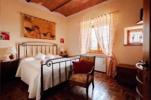 a bedroom with a bed and a chair and a window at Il ricordo del chianti in Castellina in Chianti
