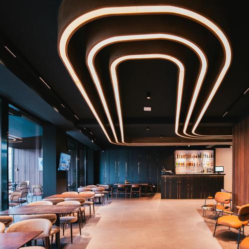 a restaurant with tables and chairs and a bar at Star Hill Hotel in Prishtinë