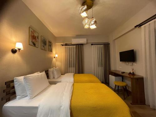 a hotel room with a bed with a yellow blanket at Kyla Kocadere Mansion in Eceabat