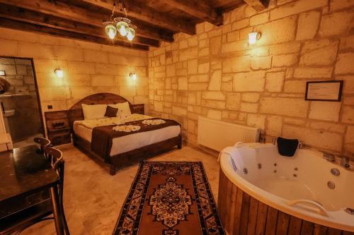 a bedroom with a bed and a tub in a room at akile ablanın evi in Urgup