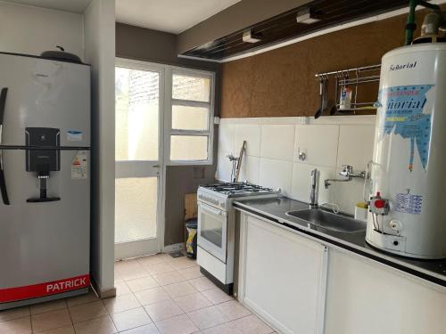 a kitchen with a sink and a stove and a refrigerator at Tu espacio ideal, Amplia y Luminosa en Rio gallegos in Río Gallegos