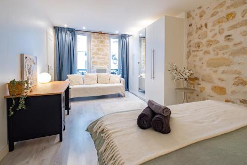 Cet appartement comprend une chambre avec un lit et un bureau ainsi qu'un salon. dans l'établissement Appartement Moderne Notre-Dame de Paris, à Paris