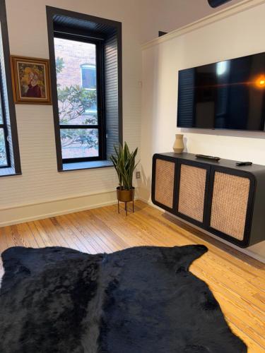 a living room with a flat screen tv and a couch at Luxe 220, Unit 2 - Front Street Suite in Wilmington
