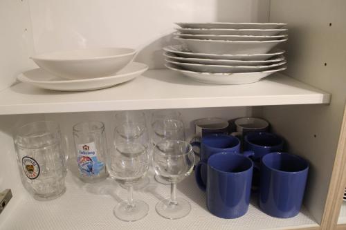 a shelf with wine glasses and plates on it at Apartment FALVIG inkl. Küche in Bad Schonborn