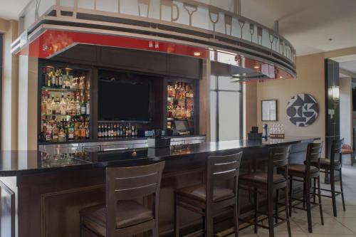 a bar with bar stools and a television at Holiday Inn Oklahoma City Airport by IHG in Oklahoma City