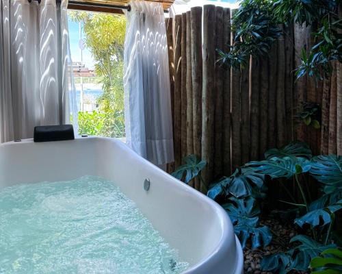 a bath tub in a bathroom with a fence at Hotel Boutique Recanto da Passagem in Cabo Frio