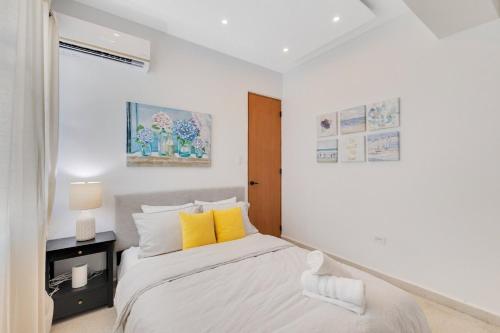 圣胡安New! Modern 3BR Near Beach & Nightlife的白色卧室配有黄色枕头的床