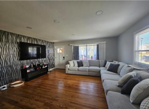 a living room with a couch and a flat screen tv at Welcome in Woodlawn