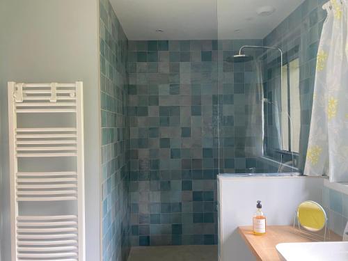 a bathroom with a sink and a shower with blue tiles at Chambre d'hôtes Les Îles Vagabondes in Saint Malo