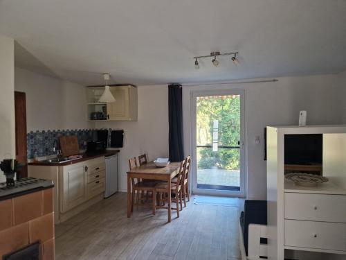 a kitchen and dining room with a table and a window at Bungalow 1Eickhof in Warnow