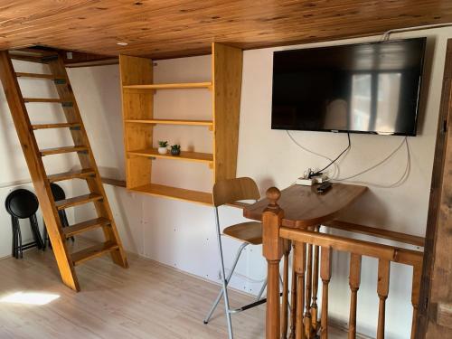 Cette chambre comprend un lit en mezzanine, une télévision et un bureau. dans l'établissement Maison individuelle chaleureuse au calme, à Bourg-Saint-Maurice