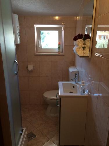 een badkamer met een toilet, een wastafel en een raam bij Apartments Crnjac in Trogir
