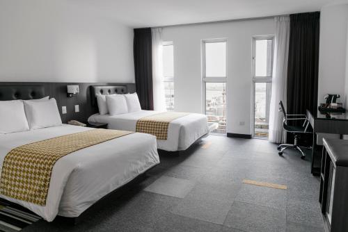 ein Hotelzimmer mit zwei Betten und einem Fenster in der Unterkunft Wyndham Costa del Sol Lima Airport in Lima