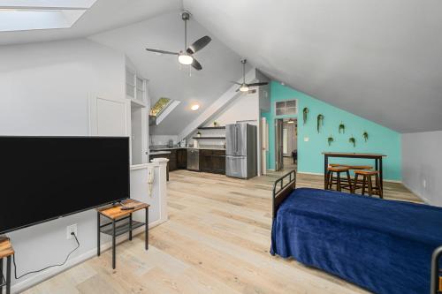 a room with a bed and a large screen tv at Cozy & Spacious Montrose Retreat with 3BR Near Houston Attractions in Houston