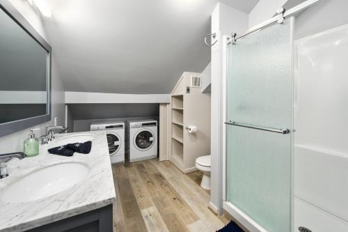 a bathroom with a sink and a washing machine at Cozy & Spacious Montrose Retreat with 3BR Near Houston Attractions in Houston