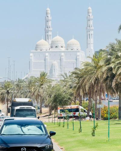 a car parked in front of a building with palm trees at Muscat Dormitory Male&Female in Muscat