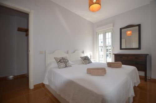 イスラ・デル・モラルにあるSan Bruno Duplex SOLMARESの白いベッドルーム(大きな白いベッド1台、枕2つ付)