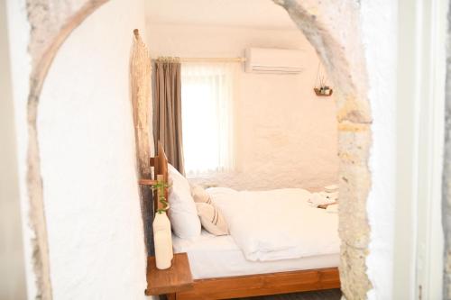 una cama en una habitación con ventana en Mahzen Alaçatı, en Alacati