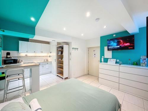 Il comprend une cuisine avec des placards blancs et une télévision murale. dans l'établissement ☆ Mise au vert ☆ Studio tout confort ☆ NETFLIX ☆, à Metz