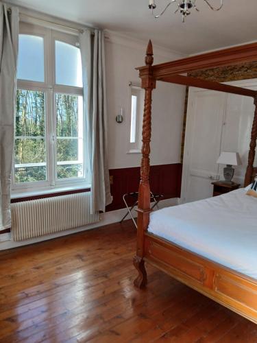 - une chambre avec un lit à baldaquin et 2 fenêtres dans l'établissement spa suite Calèche, au chateau au milieu d un bois en baie de somme, à Mons-Boubert