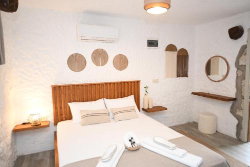 Un dormitorio con una gran cama blanca y espejos en Mahzen Alaçatı, en Alacati