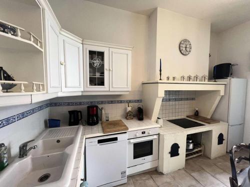 une cuisine avec des armoires blanches et un évier dans l'établissement Résidence 027-soulac Sur Mer - 027 - Jolie Soulacaise en plein cœur de la Station MAE-6891, à Soulac-sur-Mer