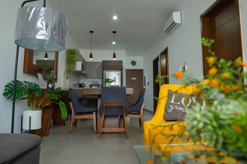 Una sala de estar con un sofá amarillo y una cocina. en few steps from the beach, at golden zone, en Mazatlán