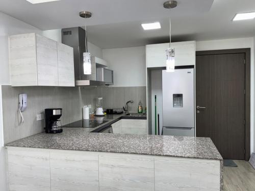 a kitchen with white cabinets and a counter top at Itsahome Selection - Torre Foresta - 3C in Quito