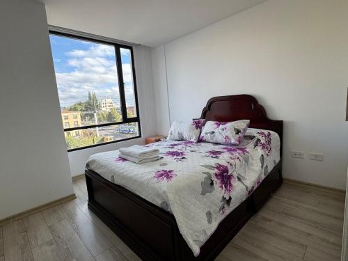 a bedroom with a bed and a large window at Itsahome Selection - Torre Foresta - 3C in Quito