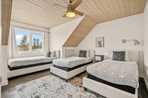 a bedroom with two beds and a ceiling at Radiant Retreat -Spacious Home - Heart of Radium! in Radium Hot Springs