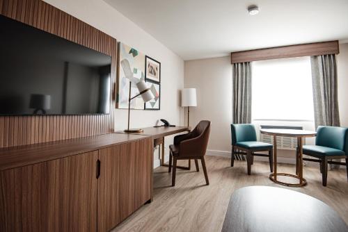 a hotel room with a television and a table and chairs at Holiday Inn & Suites Winnipeg Downtown by IHG in Winnipeg
