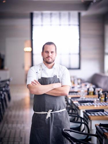 a man standing in a kitchen with his arms crossed at Kimpton Brice Hotel by IHG in Savannah