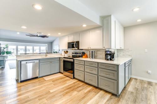 a large kitchen with stainless steel appliances and wood floors at Waterfront Home with Deck and Pool in City-by-the-Sea in City-by-the Sea