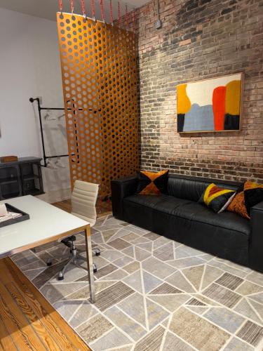 a living room with a couch and a brick wall at Luxe 220, Unit 7 - Entire Penthouse Property - sleeps 20 in Wilmington