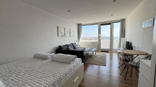 a bedroom with a bed and a living room with a couch at Penthousewohnung mit traumhaften Ausbilck auf den Segeberger See in Bad Segeberg