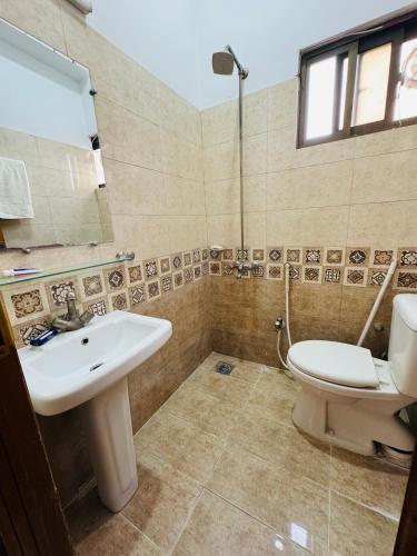 a bathroom with a sink and a toilet and a mirror at 2 Bedrooms Deluxe Family Apartment Islamabad-HS Apartments in Islamabad