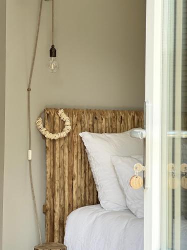 a bedroom with a wooden headboard and a bed with white pillows at Chambre d'hôtes Les Îles Vagabondes in Saint Malo