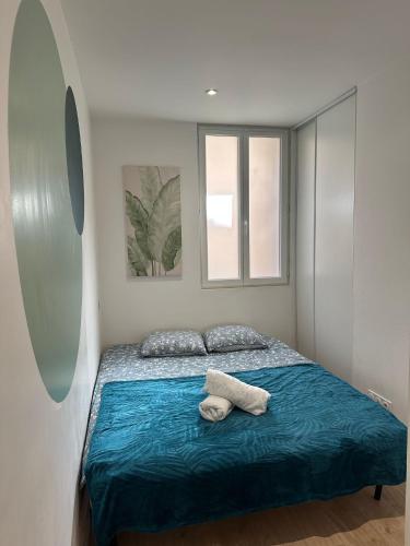 - une chambre avec un lit avec une couverture bleue et 2 fenêtres dans l'établissement Cœur d'émeraude, à Moissac