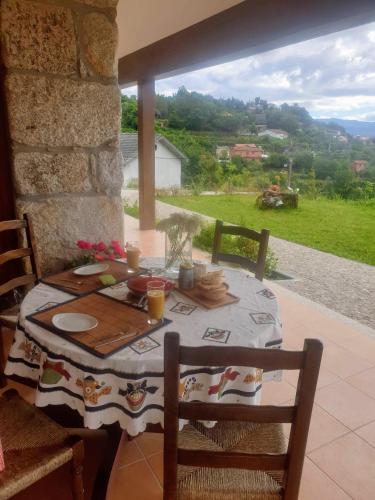 a table and chairs with a table and a window at Tapadas do Sol in Couto de Esteves