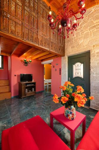 a living room with a red couch and a vase with flowers at Eleftherias Garden House in Afantou
