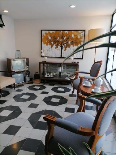 a living room with a fireplace and a table and chairs at Entre Patios Hotel Boutique in León