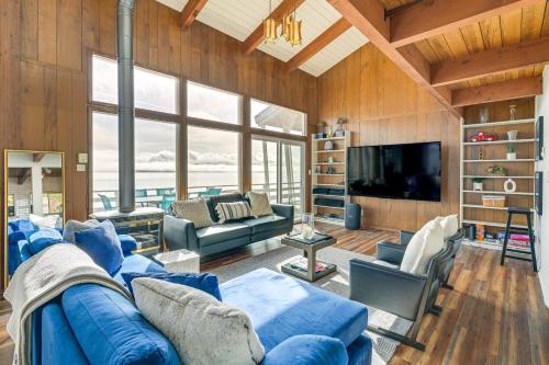 a living room with a blue couch and a tv at Decks and Views Waterfront Shelton Home in Shelton