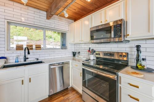 a kitchen with white cabinets and a stove top oven at Decks and Views Waterfront Shelton Home in Shelton