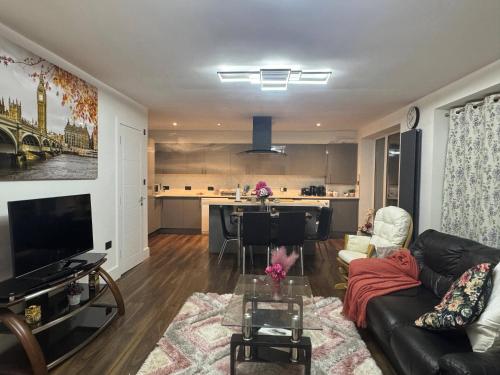 a living room with a couch and a table at Contemporary 2 bed house with Parking in West Thurrock