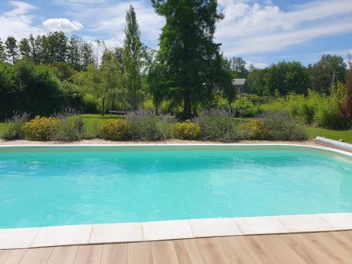 une grande piscine bleue dans une cour dans l'établissement Gîte du Paradis Normand, à Courtonne-la-Meurdrac
