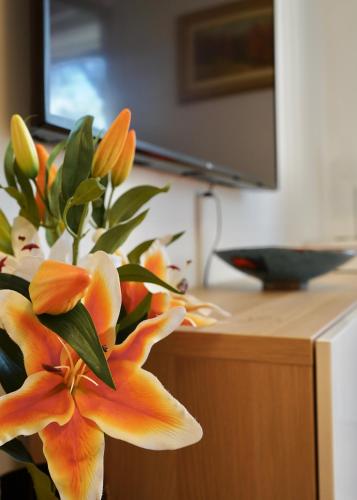 a bouquet of orange flowers sitting on top of a counter at Wilena Apartments in Villach
