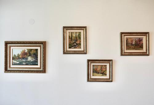 a group of framed paintings on a wall at Wilena Apartments in Villach