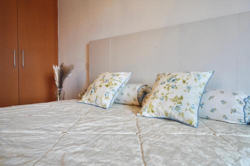 a bed with four pillows on top of it at Wilena Apartments in Villach