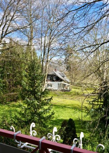 a house in a field with a tree and a fence at Wilena Apartments in Villach