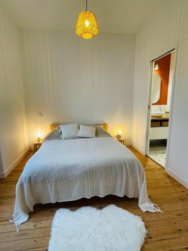 - une chambre avec un grand lit et 2 tapis blancs dans l'établissement Cozy apartment Chez Simone, à La Rochelle